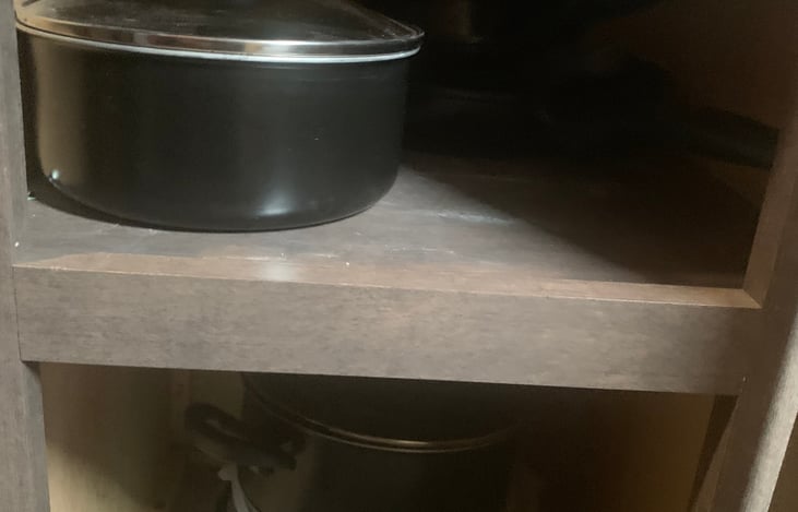 Right of stove- pots, pans and mixing bowls