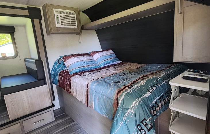 AC remote provided shown on top of shoe rack on the right. Under bed storage: camper chairs up to 6.