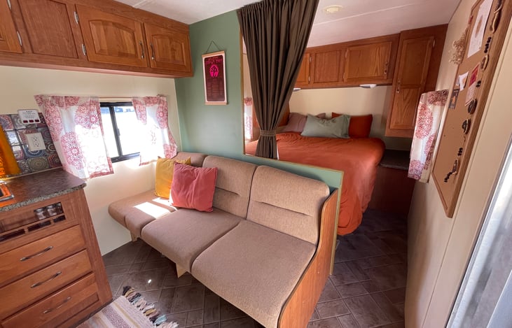 Front side of camper.
The couch can convert into a sleeping space for 1 adult or possibly two children side by side.
Sheets & extra blankets provided in storage space under couch.