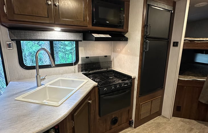 Kitchen with sink, microwave, stove, oven, freezer, and fridge
