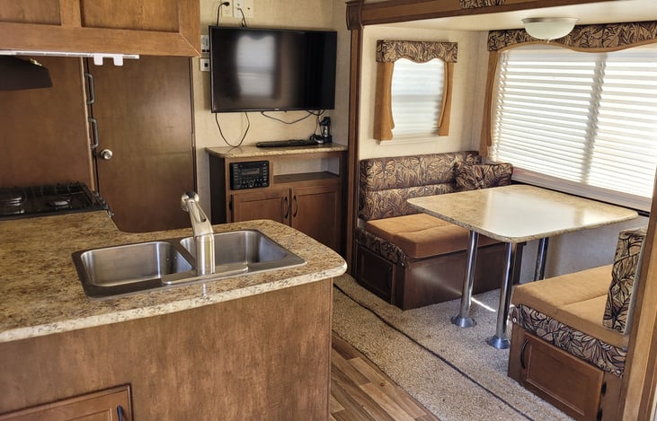 Main Living Area: Dinette (with storage underneath), TV, Radio/DVD/CD, Cabinets (Pots & Pans + additional space), 2-vessel Sink, Countertop, Range top, hood, Bathroom Door