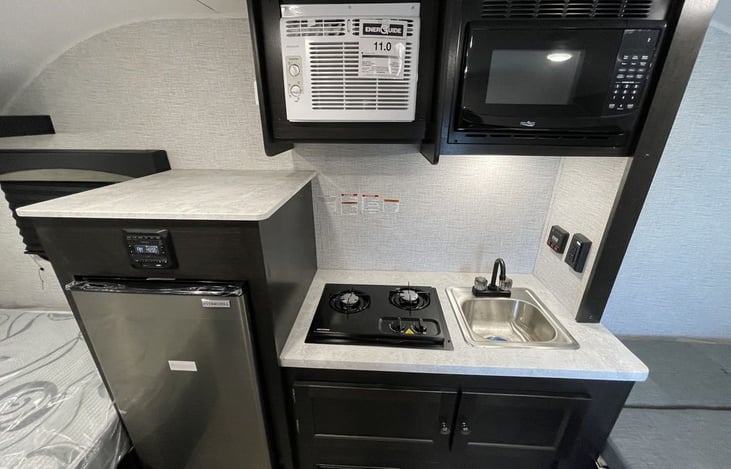 2 Burner Cooktop, Microwave, Built-in Sink w/ Integrated Faucet, Fridge and freezer.