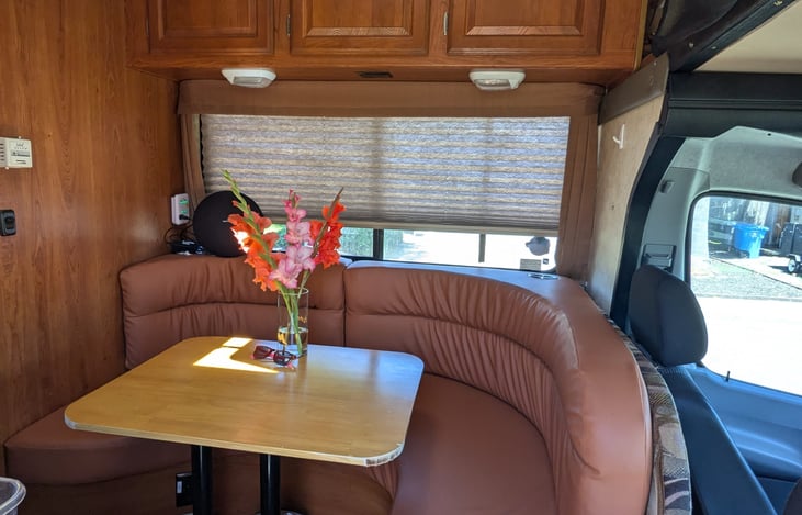 Custom dinette with phone chargers, flower vases and butcher block table.