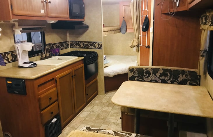 Kitchen area with table.  Table turns into another full bed.