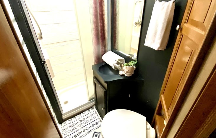 Private RV bathroom with toilet and shower — all the essentials for your motorhome rental experience.