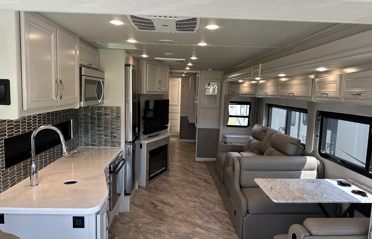 Main area with reclining chairs, full kitchen w/ stove, microwave, double door stainless fridge and dimmable lighting