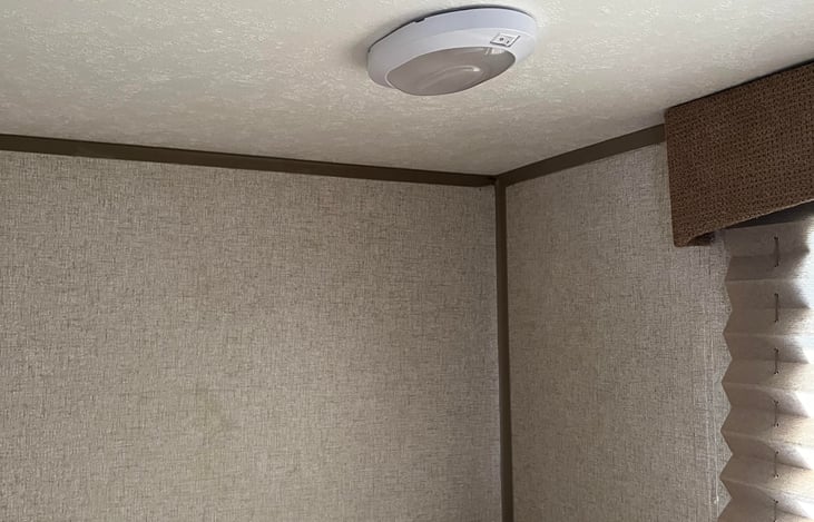 Cell phone outlet charger, light switch, and window near upper bunk