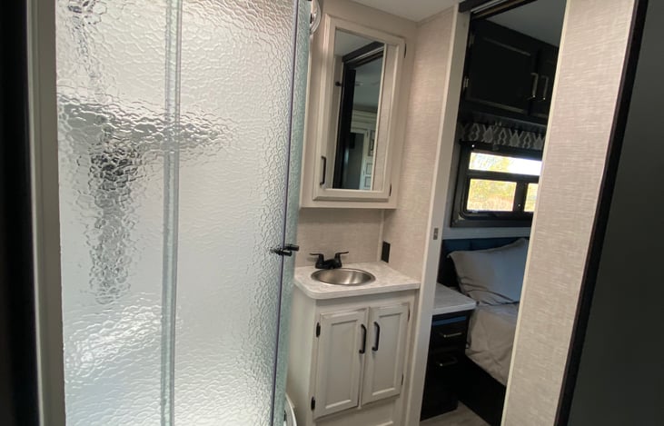 Bathroom area includes shower, toilet, and vanity