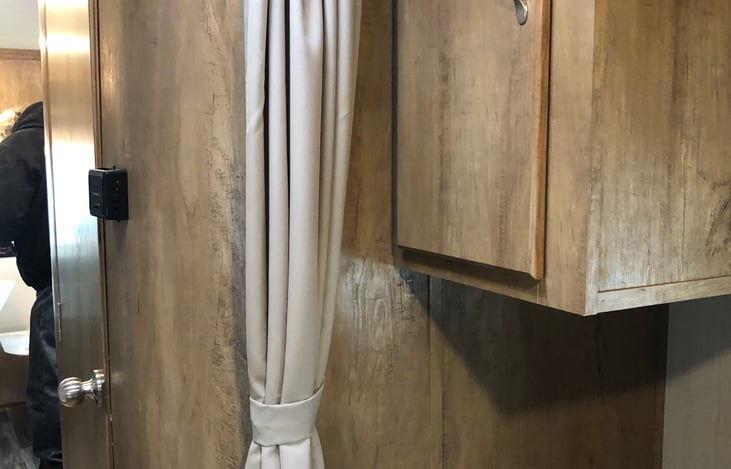 In mid-section of  trailer, curtain available for additional privacy between bathroom/shower and bedroom area