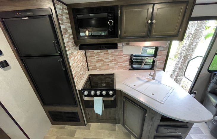 Kitchen area - Microwave, 3 burner cooktop, oven and Refrigerator