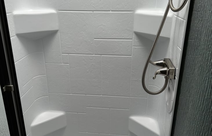 Shower has skylight and basket for shower essentials