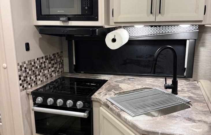 Fully loaded kitchen, equipped with dishes, utensils, mittens and more.