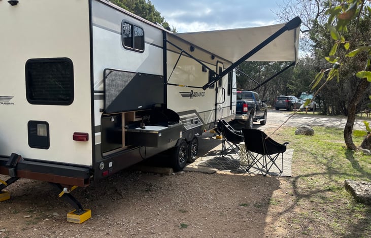 Comfortable outdoor setup with power awning, seating, rug, and exterior kitchen — designed for relaxing, dining, and enjoying the outdoors.