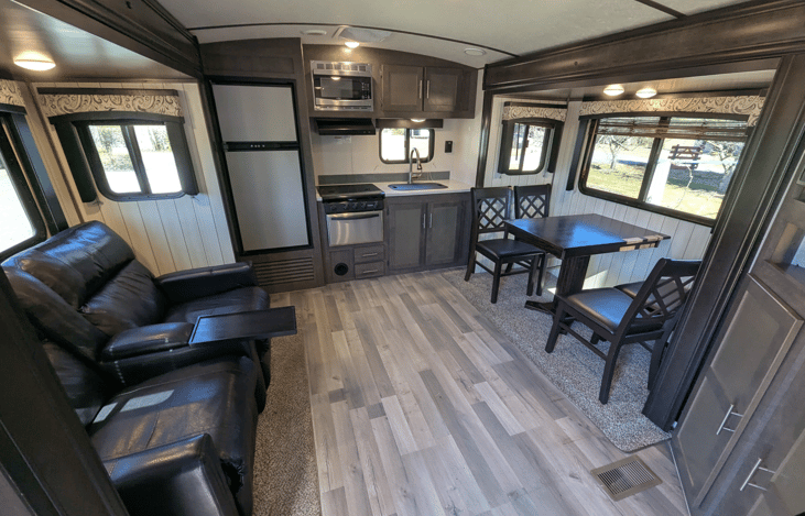 Very spacious living area offers a cozy retreat with theater-style recliners, a premium entertainment system, fireplace, TV, dinette and well-equipped kitchen.