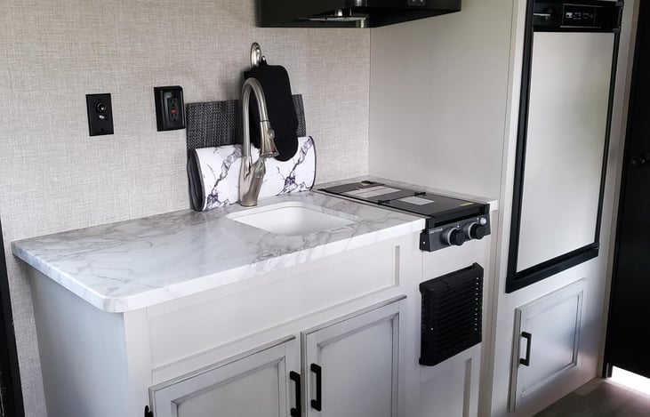 Kitchen includes 2 Burner Stove and Oven, Refrigerator, Microwave, and everything you'll need to prepare and enjoy a meal!