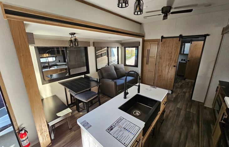 Kitchen, dining and living room. Includes smart tv, sofa/recliner, island sink, gas cooktop and oven, microwave, full-size refrigerator/freezer, pantry storage, dining table/chairs for 4 person