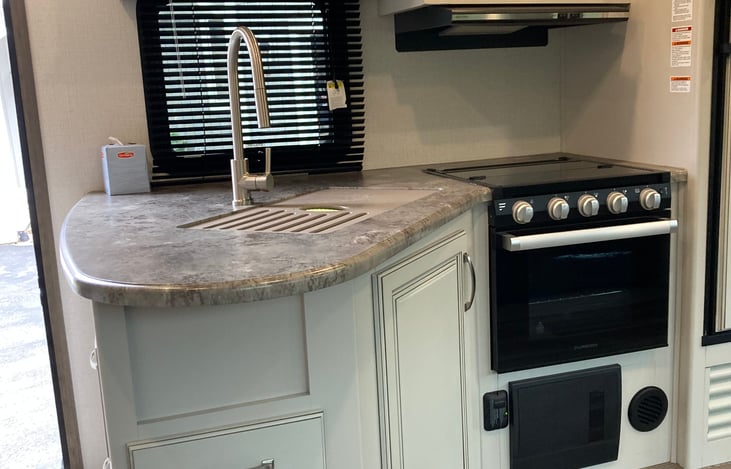 Island kitchen provides room for cooking delicious meals.  It’s equipped with microwave, oven, convenient-sized refrigerator.