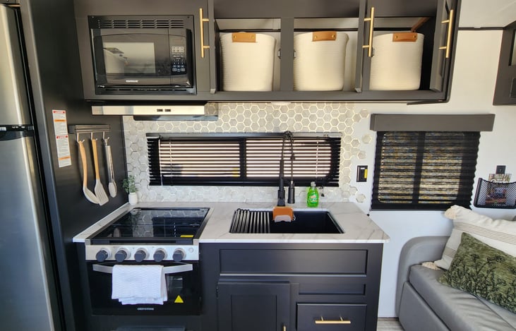 Baskets in overhead cabinets make for great organization. Dishes/silverware, cleaning supplies, and cooking supplies.
