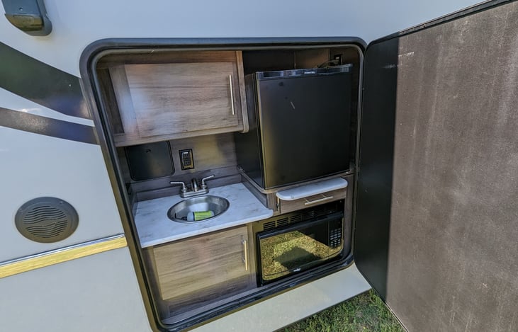 Outdoor kitchen with sink, microwave, and mini fridge!