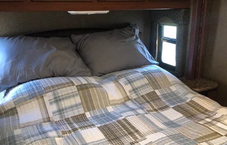 Queen size bed, mirrored closets, TV, storage behind the TV, and over bed storage.