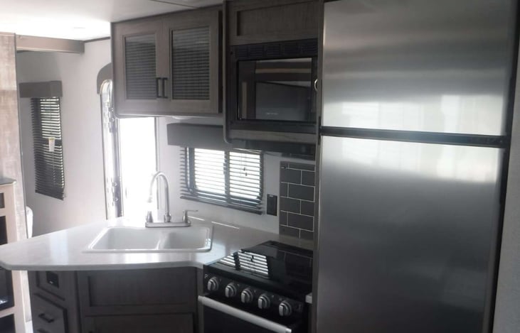 Indoor kitchen with stainless steel fridge.
