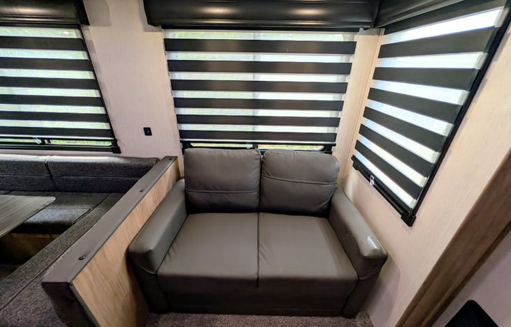 Spacious dinette and cozy couch surrounded by windows both convert to comfy beds.