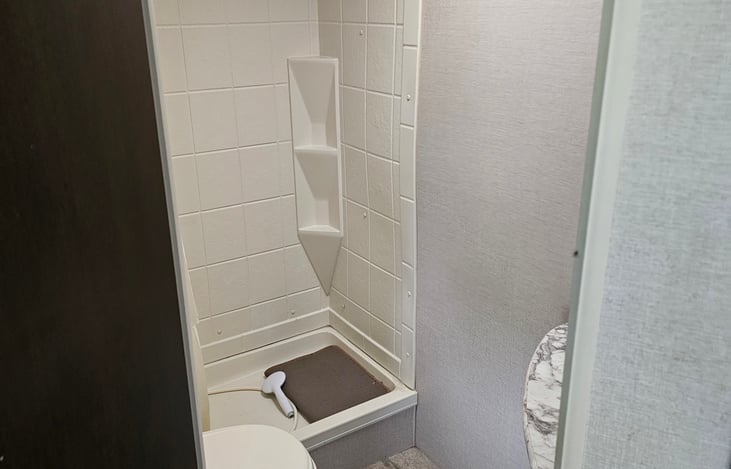 Bathroom with toilet, shower, and sink