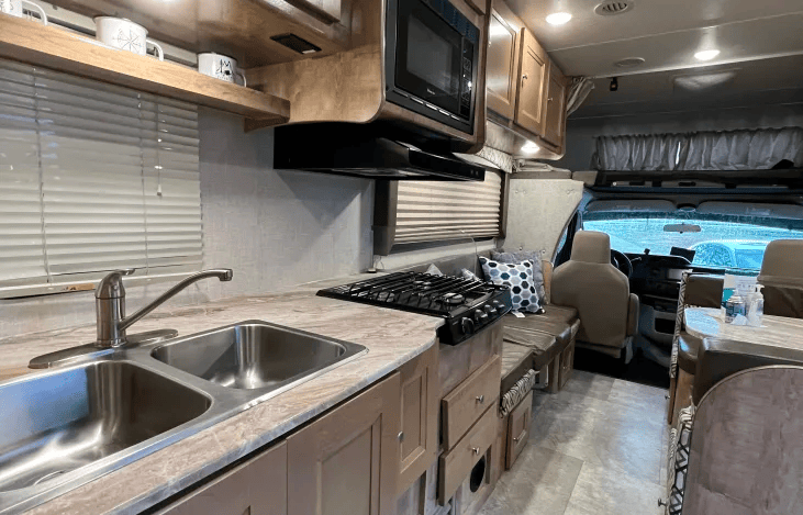 Fully functioning kitchen includes gas stove, fridge, and microwave. The RV will also include reusable dishes, pots and pans, utensils and basic cleaning supplies.