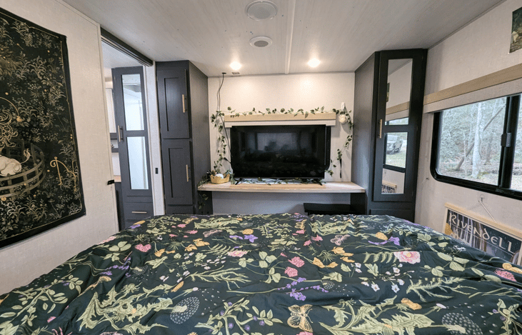 Comfortable, bright, and spacious bedroom slideout with Queen bed, large TV and whimsical touches to make it feel cozy and magical.