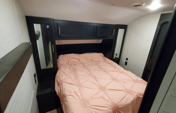 The front bedroom has a private door both to the interior space and exterior space with a queen size bed.