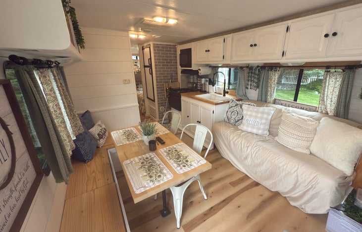 Farmhouse style throughout, wrap around bench seating, and a convertible couch that folds down into a comfy bed right in front of the tv.