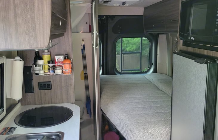 Picture of the Frig, closet, Microwave and back sleeping area.