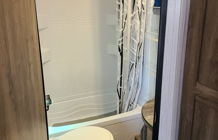 Bathroom includes towel sets, toilet paper, and some toiletries.