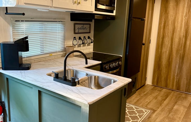 Double sink and pantry stocked with bins for holding any necessary items you may want to bring along including the important snacks!