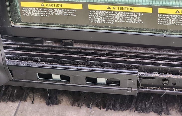 The rear window / screen door has two tabs to lock the windows in place before travel