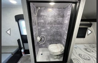 Yes it has a bathroom. Small easy to tow 3200lbs.