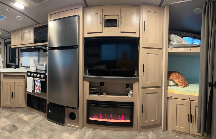 Entertainment center with TV, Bluetooth audio, DVD player, electric fireplace, and ample storage.