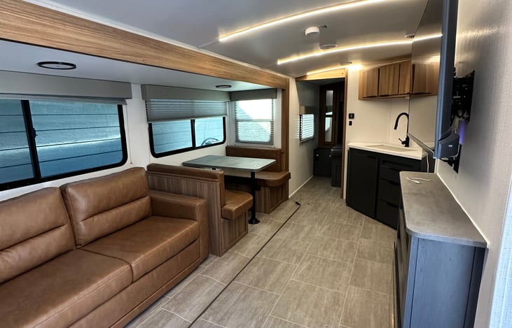 The living room with a couch that opens up into a Q size bed, a dinette that opens up into a smaller bed.