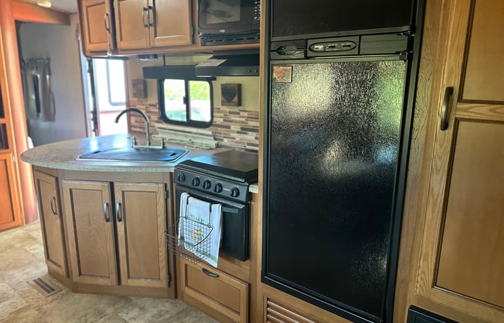 Oven and Stove have never been used before. We cook outside.  Double sink with cover. Microwave, and a good size refrigerator.