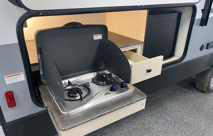 Outdoor Kitchen with pull out 2 burner cooktop, mini refrigerator, and drawer