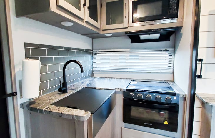 Sink, Stove, Microwave and Storage.