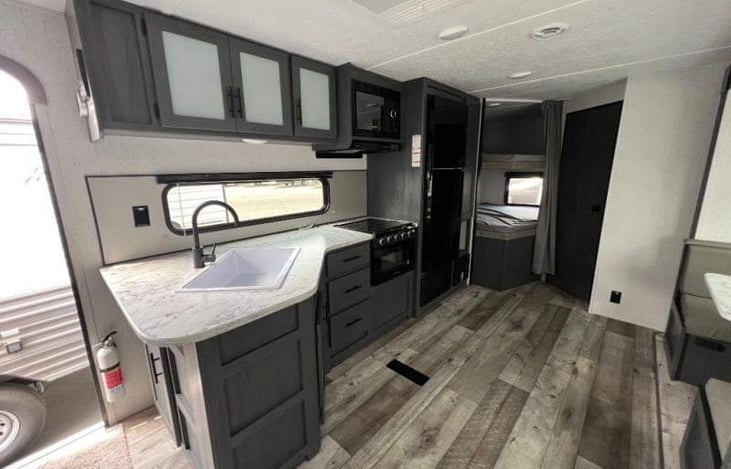 Kitchen and double bunk beds which will comfortably sleep 2 small kids side-by-side with a USB port on top bunk and a privacy curtain when it’s bed time.