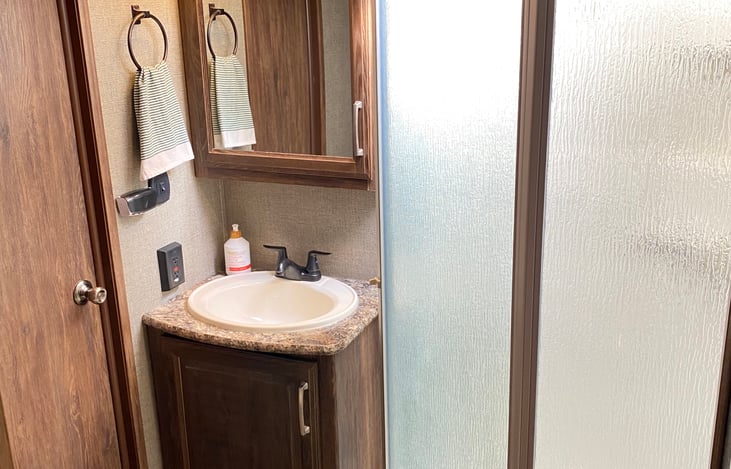 Bathroom is spacious with two doors, upgraded oval porcelain toilet with included RV approved toilet paper.