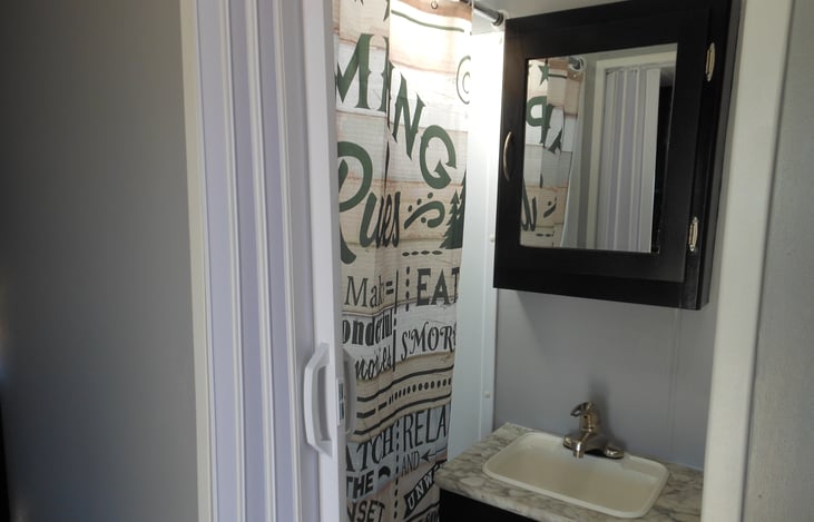 Bathroom has shower with detachable head, sink and toilet.