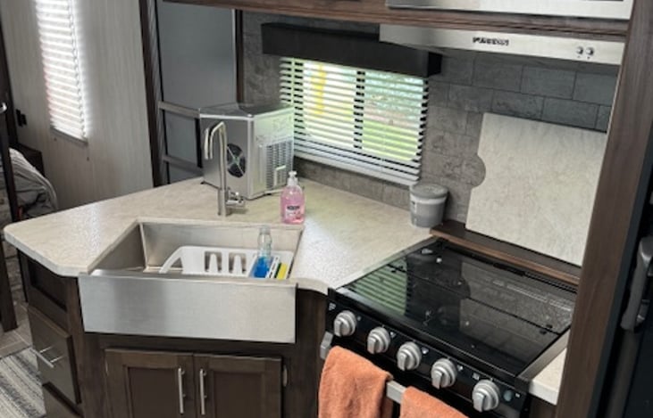 The farmhouse style sink, along with the 3 burner stove, oven, and fume hood provide all of the amenities of home.