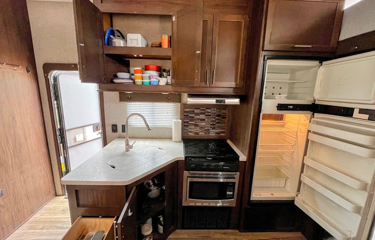 Kitchen comes equipped with dishes and utensils. Convection microwave and freezer can fit a rectangle pizza from Costco for reference.