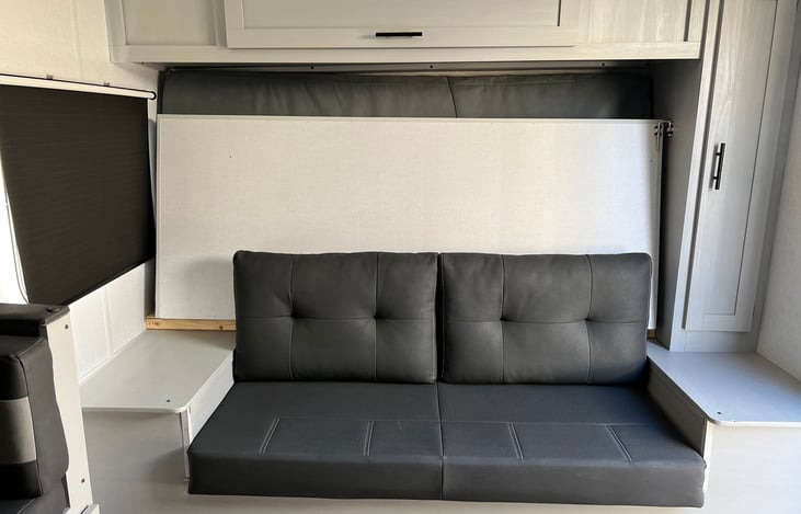 Couch which converts to Murphy bed with clothes closet and overhead storage