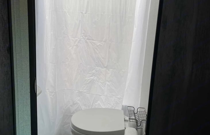 Bathroom with toilet, sink and stand up shower.