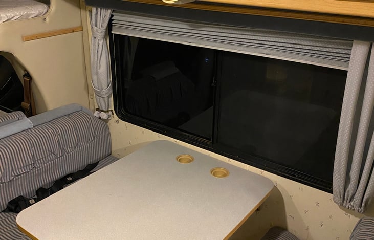 A four person removable table can be collapsed into a queen sized bed, or left as is. There are four seat belts at the table, so you can safely sit at the table while the vehicle is on the road.