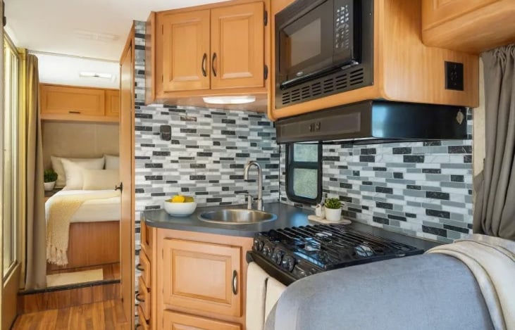 Cook and relax in this Thor Majestic 28A Las Vegas RV rental — a cozy kitchen setup in a pet friendly RV that sleeps 6 and feels like home